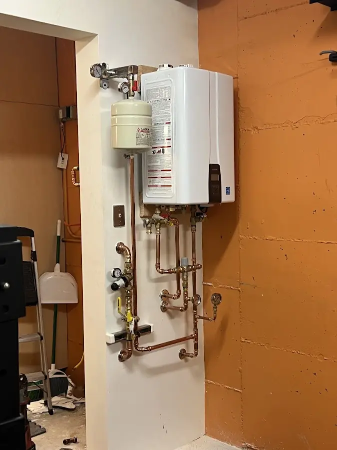 Plumbing technician inspecting water heater connections in Flora